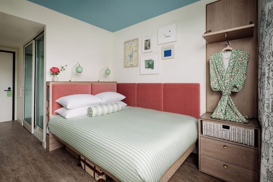 Unwind on crisp linens in a cheerful, designer room.