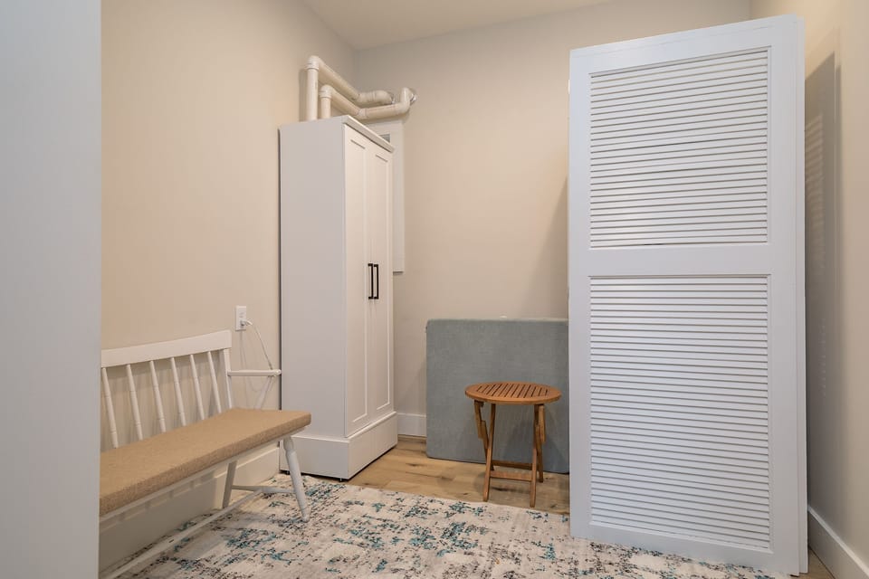 Main floor laundry room with stackable washer and dryer and on-demand water heater