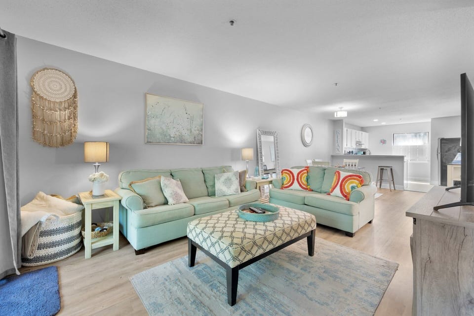Living room with flat screen tv and access to a screened in patio.