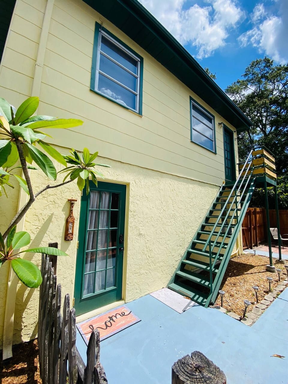 Entrance to apartment is the green door to left at bottom of stairs.