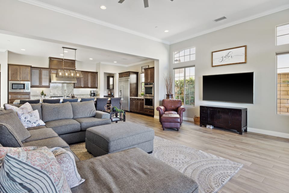 Sectional seating with TV—open concept flows to kitchen.