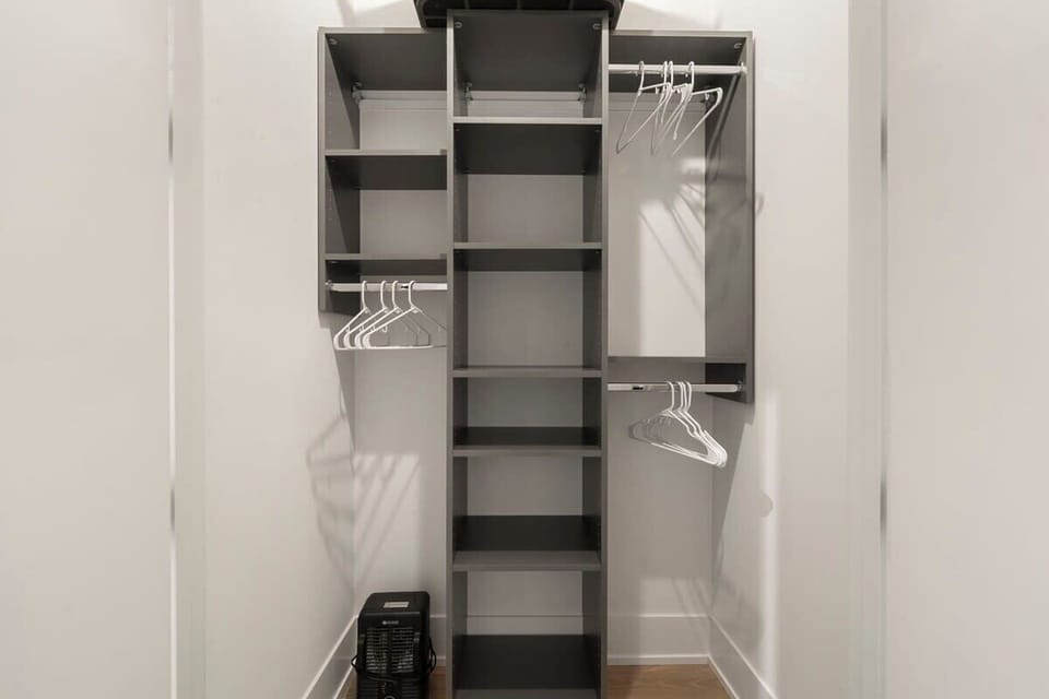 Tall closet shelves keeping everything neatly stored.