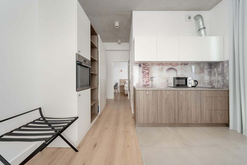 A modern kitchenette with essential appliances, perfect for preparing simple meals and snacks. Features a microwave, coffee maker, and elegant cabinetry.

