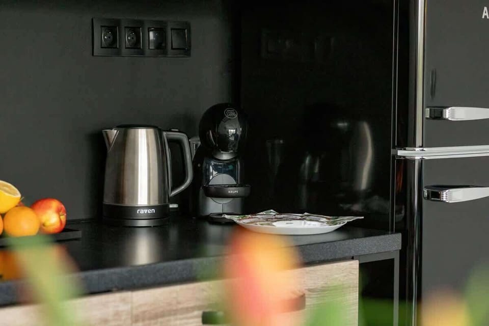 A stylish kitchen corner featuring a coffee maker, electric kettle, and modern appliances.

