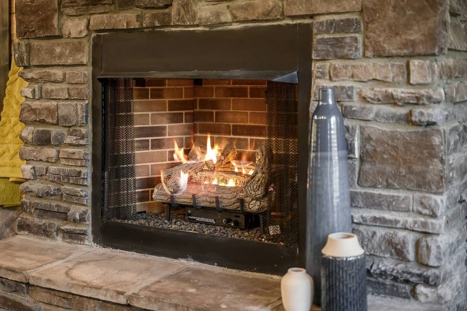 Warmth and ambiance abound by the crackling fireplace, perfect for cozy evenings indoors.