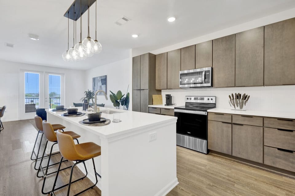 Modern kitchen with a sleek dining area, perfect for cooking, serving, and enjoying meals in style during your short-term rental stay