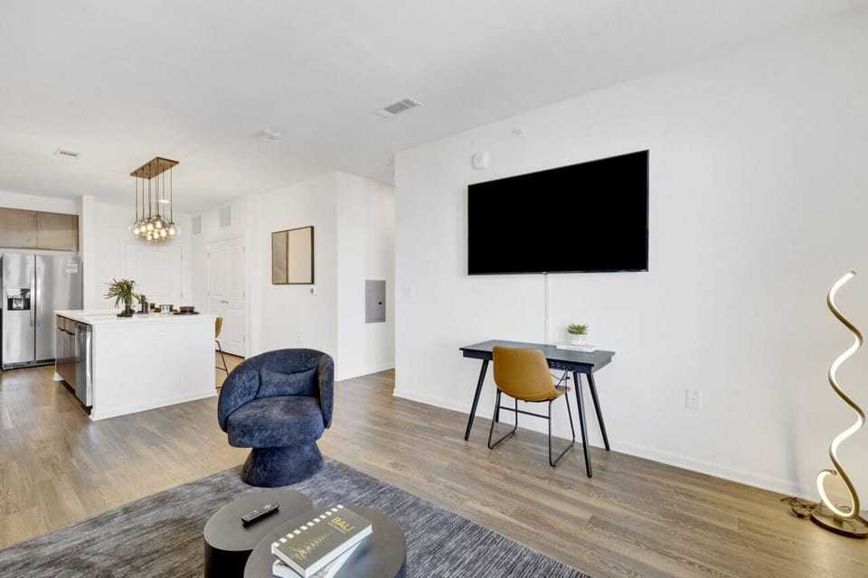 Relax in a stylish living area featuring a Smart TV and comfortable seating, perfect for unwinding during your short-term rental stay.