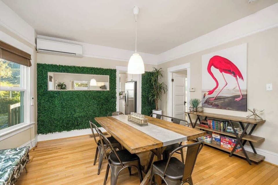Dining room with long table and colorful art.