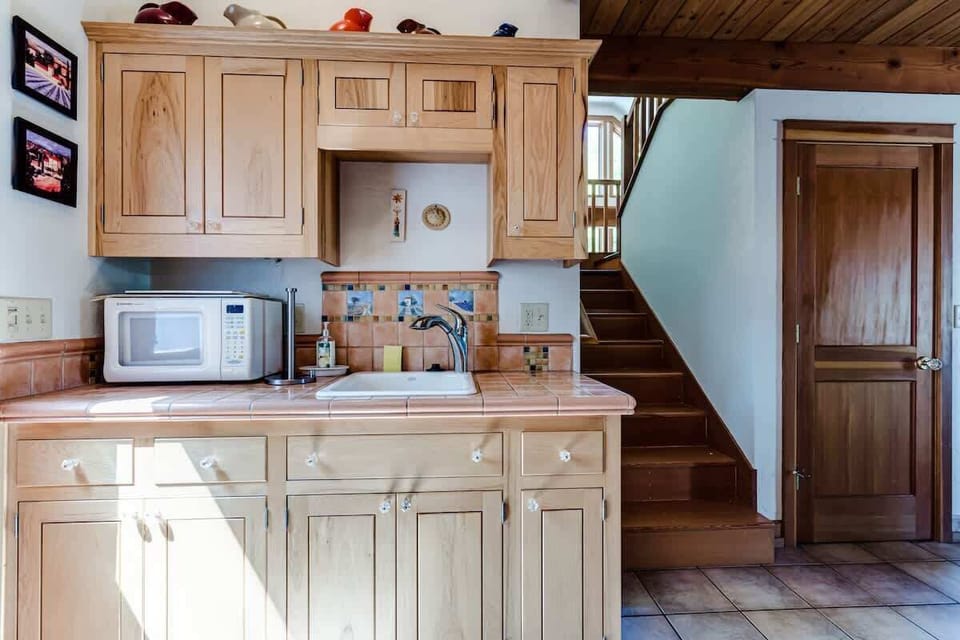 Compact kitchenette with microwave, small sink and garbage disposal, plus cabinet storage. Please note there is no dishwasher.