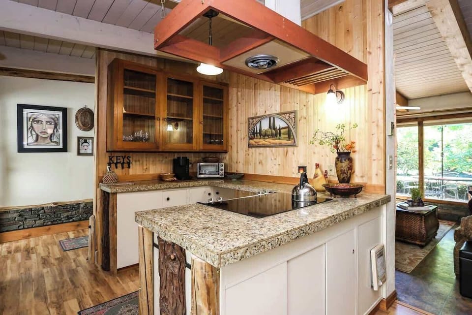 Conveniently located just off the entryway, this kitchen features a flat-top stove, toaster oven, and warm wood finishes—perfect for quick meals or full cooking sessions.