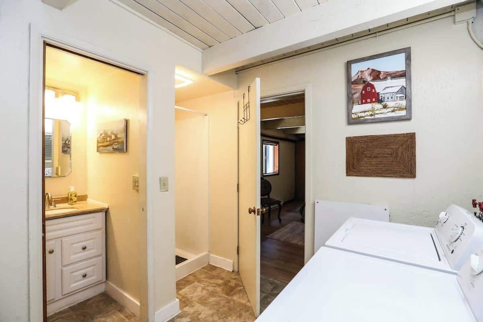Bathroom #2 features a split layout with a walk-in shower, vanity/bathroom and a laundry room with washer and dryer on the other—adding both convenience and functionality for longer stays.