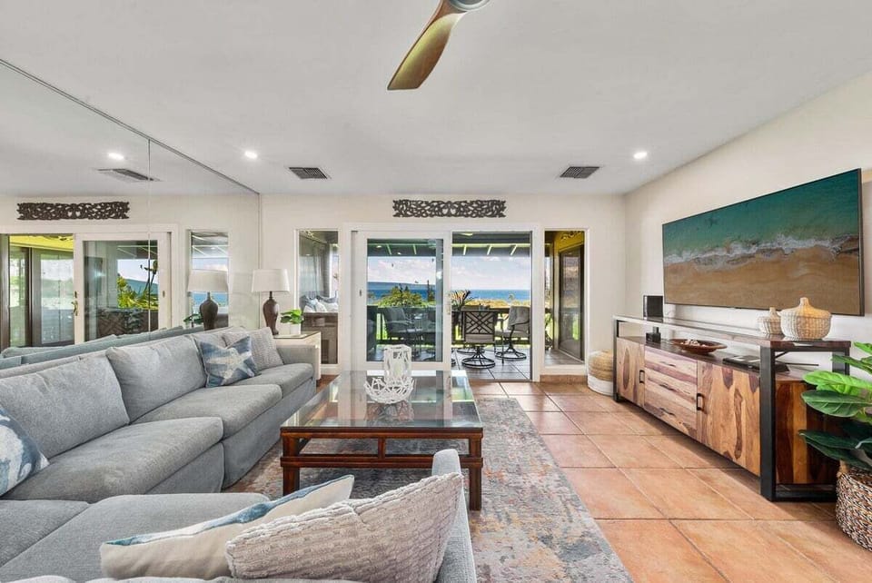 Bright and spacious living room with plush sectional sofa and stunning ocean views through large glass doors