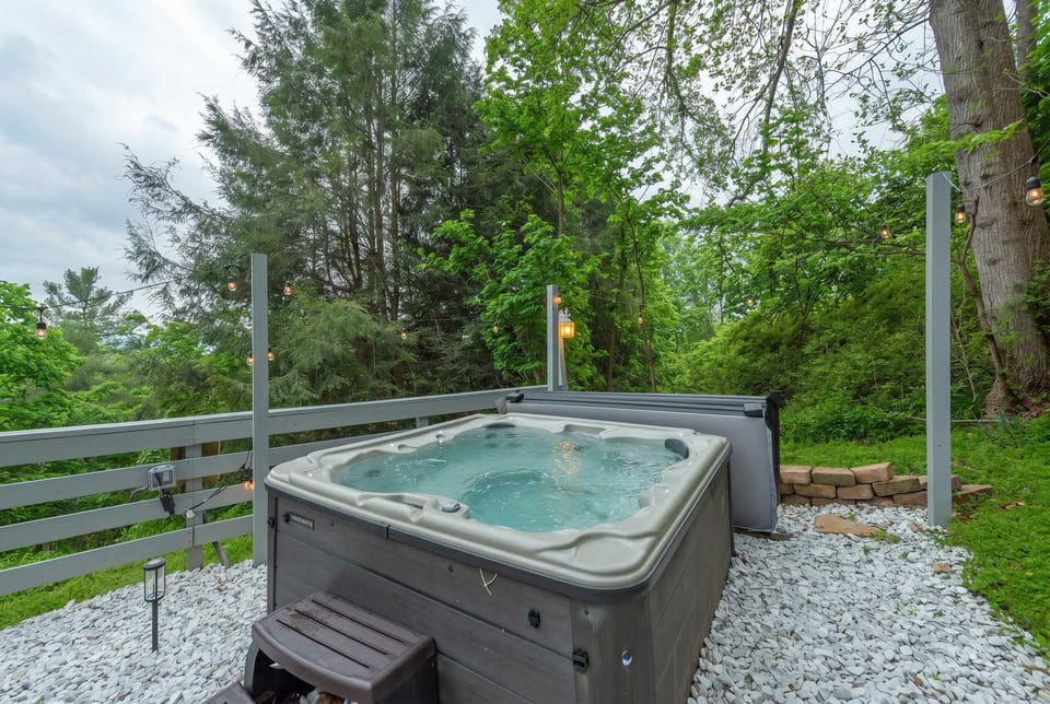 Soak & Unwind – Slip into the bubbling hot tub surrounded by lush trees and twinkling string lights for the ultimate nature retreat