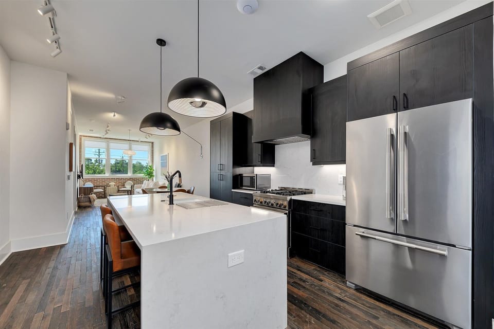 Sleek kitchen w/ large island, bar seating & stainless steel appliances