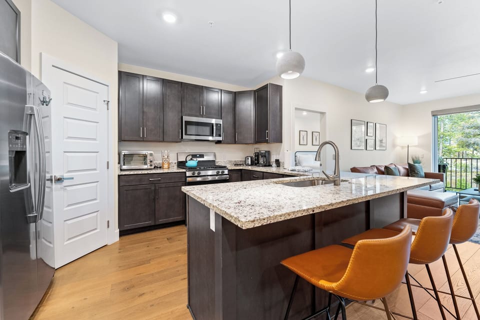 Enjoy cooking in your spacious modern kitchen featuring granite countertops, stainless steel appliances, and a breakfast bar perfect for morning coffee.