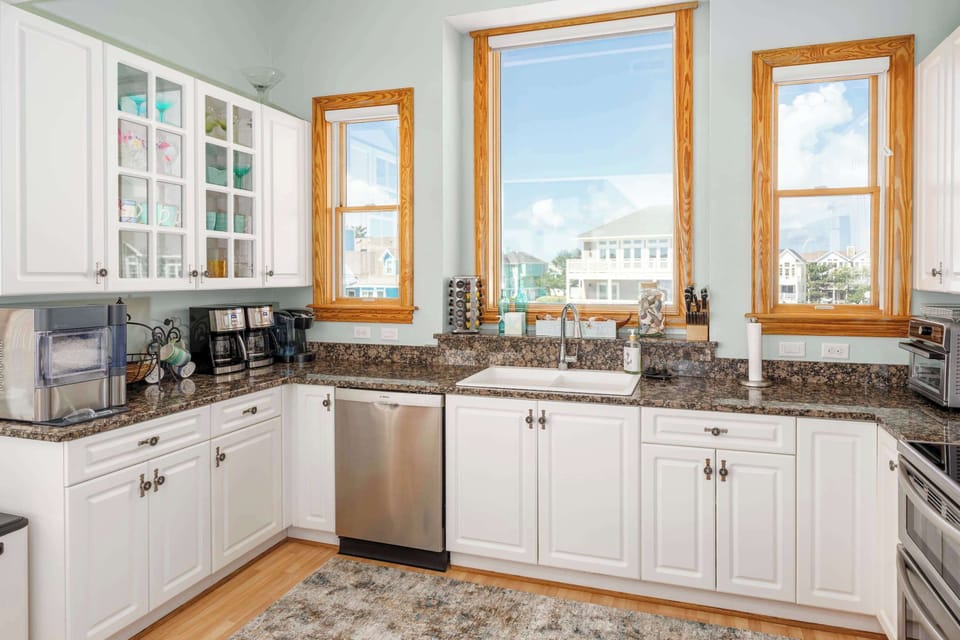 Top Level Fully Equipped Kitchen with a Refrigerator, Microwave, Dishwasher, Coffee Maker, Toaster Oven, Breakfast Bar, Natural Daylight, and Scenic Views.