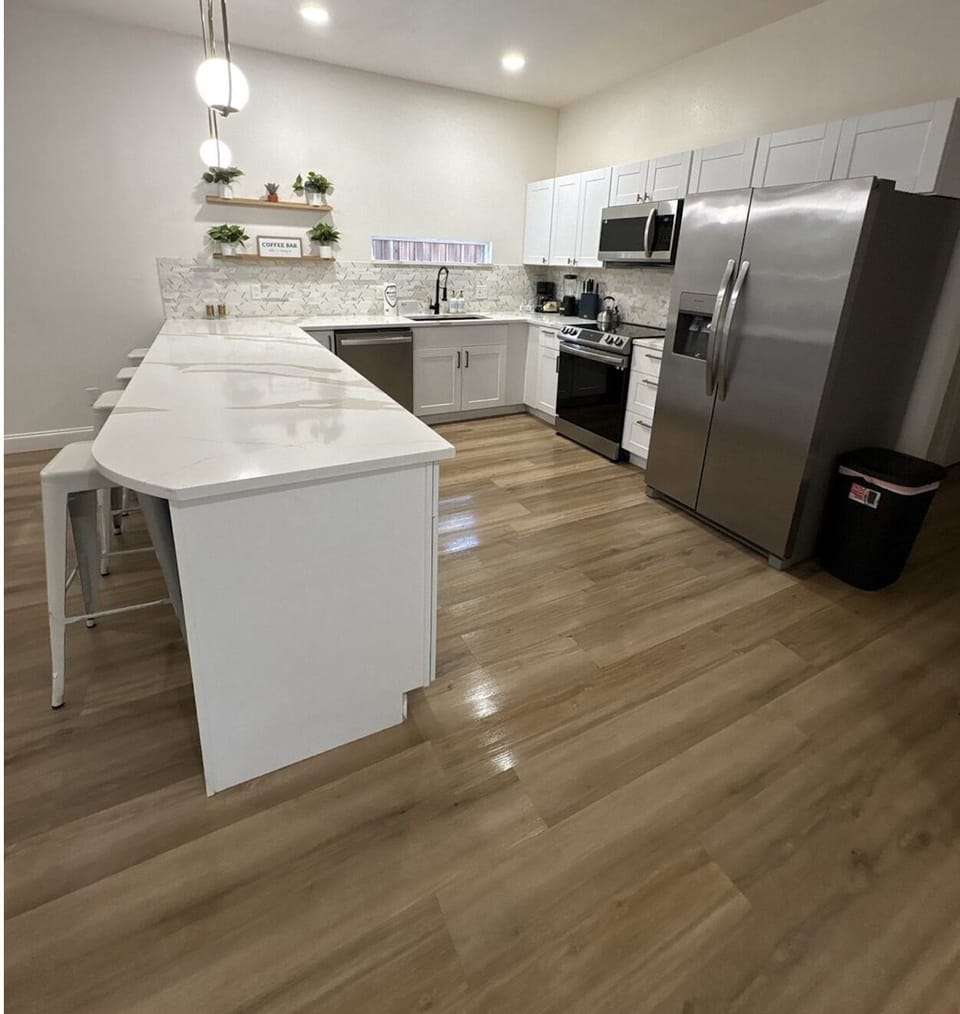 Step into your fully equipped kitchen, where bright white cabinetry meets warm hardwood floors. Whip up your favorite meals with stainless steel appliances and enjoy plenty of prep space at the center island.