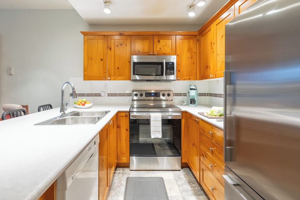 Spacious kitchen with dishwasher, large fridge, and plenty of counter space.