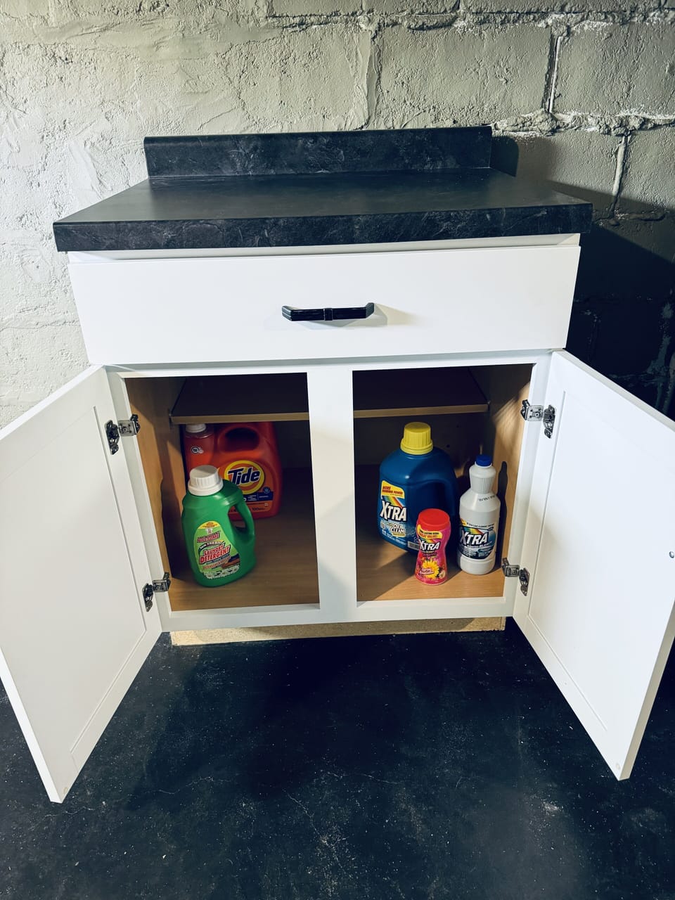 Laundry soap under the Cabinet across from the Washer and Dryer.