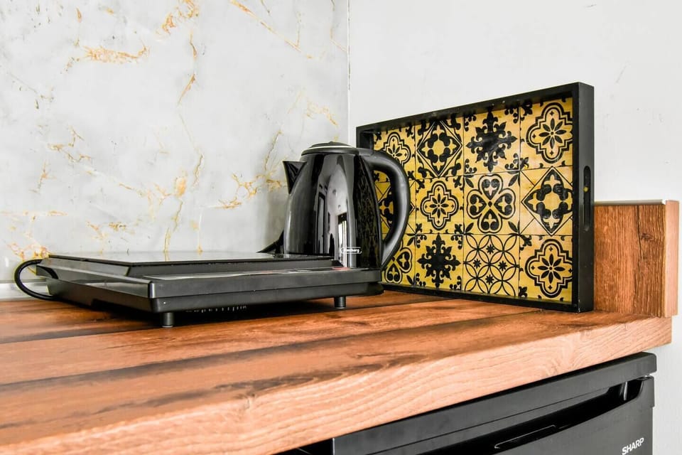 Morning essentials: sleek hotplate and kettle set against marbled elegance.