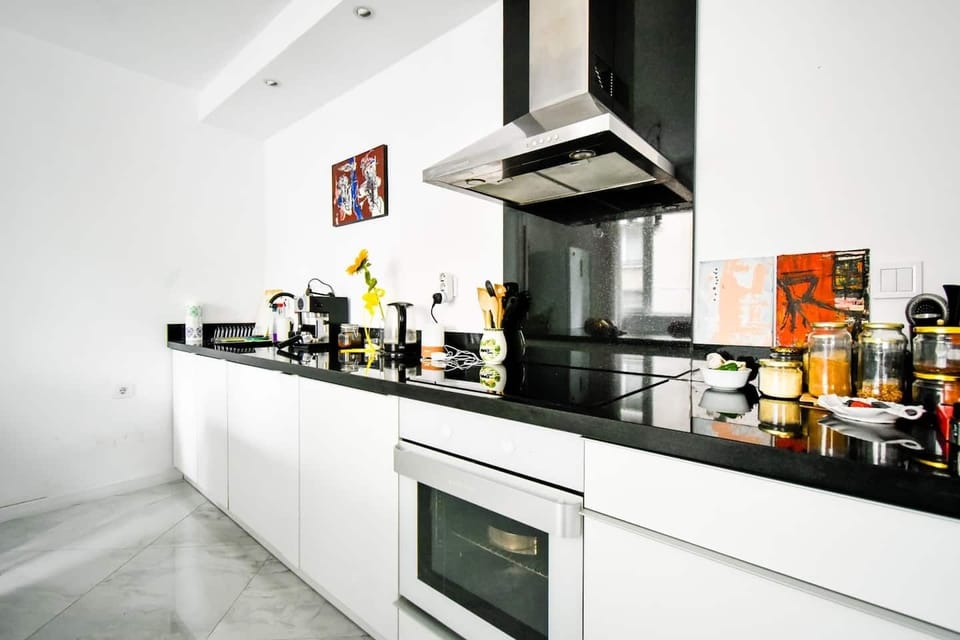Overhead view of a modern kitchen counter with glossy black countertops, high-end appliances, and a bright, airy feel