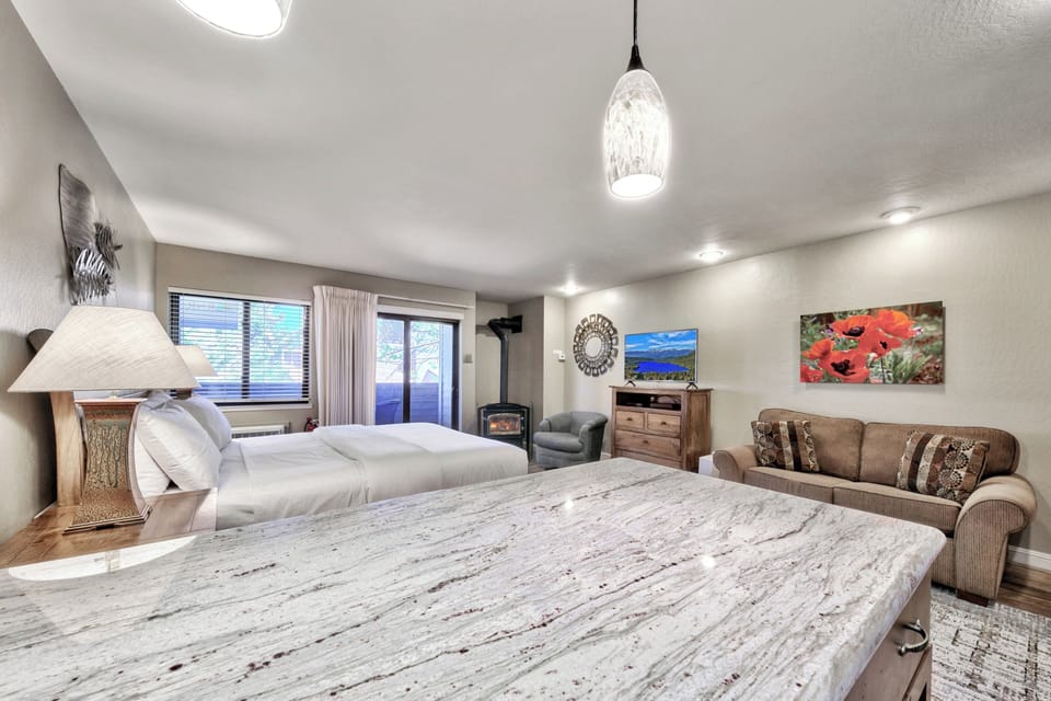 Unwind in your spacious studio featuring a comfortable beds, cozy fireplace, and relaxing seating area for the perfect mountain retreat.