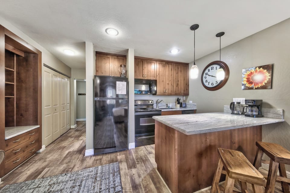 Your fully equipped kitchen awaits with granite counters, modern appliances, and a breakfast bar perfect for morning coffee or casual meals.
