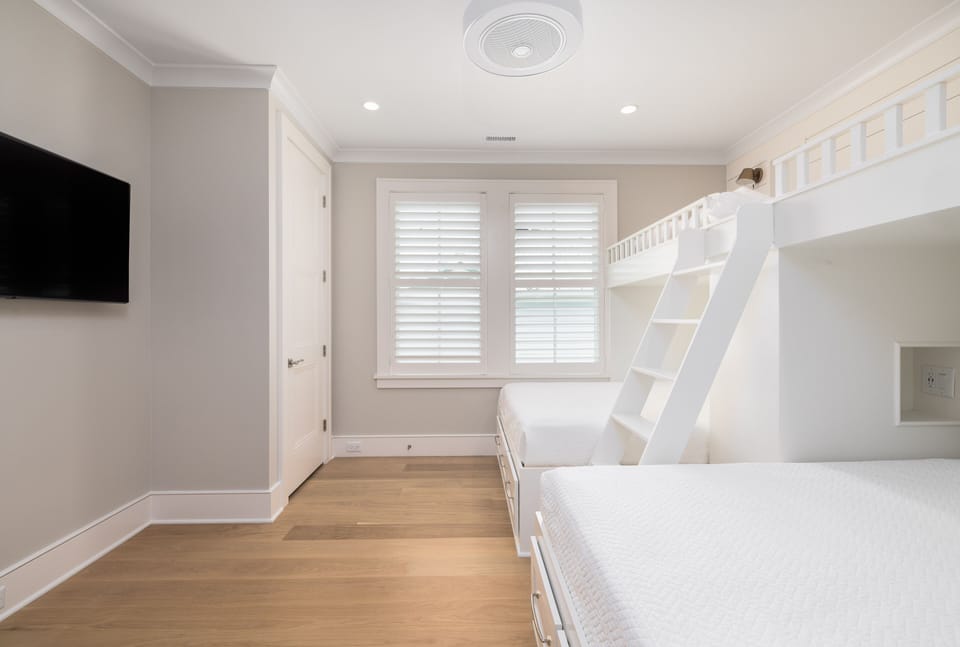 Fun and functional bunk room featuring two twin-over-queen bunks, a Smart TV, and a private en suite bathroom