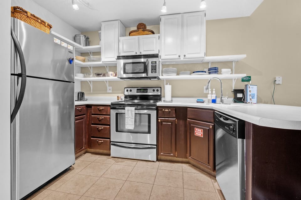 Fully equipped kitchen with stainless appliances, breakfast bar seating, and everything needed to prepare meals during your stay.