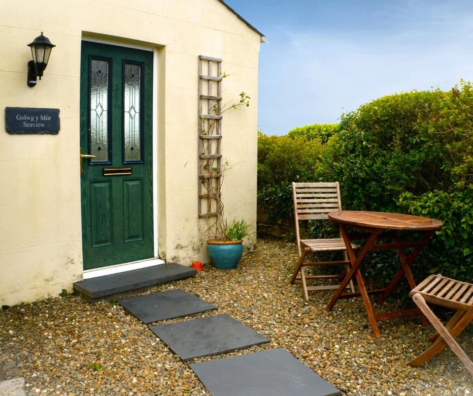 Exterior image of property with gravel and table and chairs for two