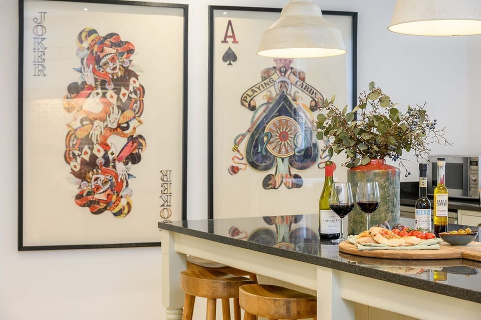 Kitchen island at 30 Frenchgate with a sink and breakfast setup, pendant lights overhead, and framed artwork on the wall.