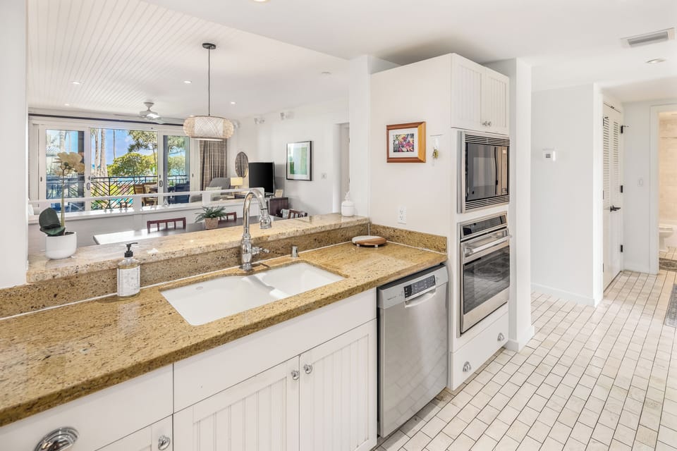 Kitchen looks through to dining area, living area & lanai/ocean views