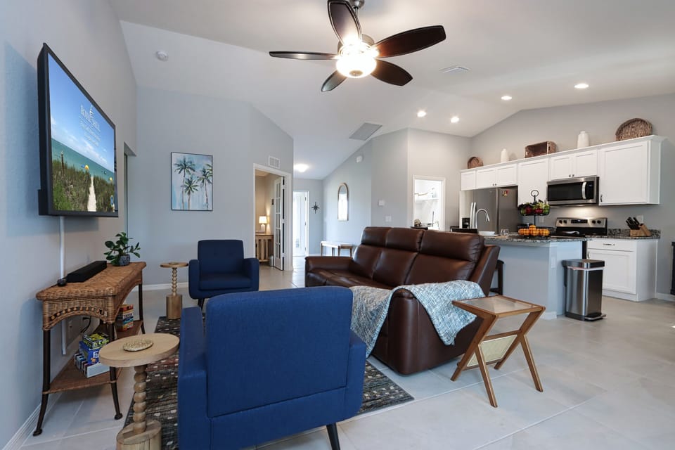 Enjoy the open-concept kitchen and living space with a wall-mounted smart TV for entertainment at a glance