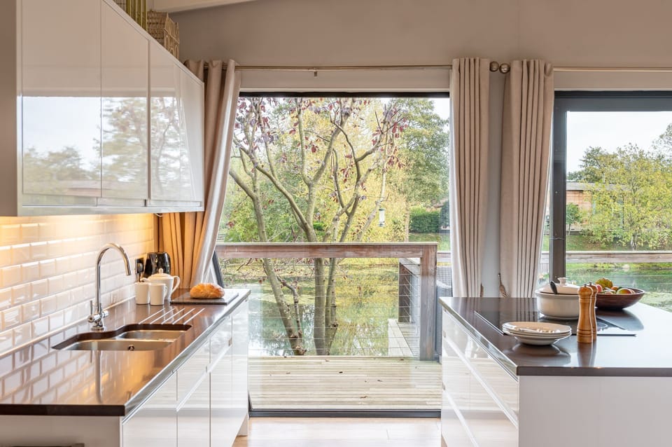 Kitchen at Abbey, with a central island and doors opening directly onto the private lakeside deck