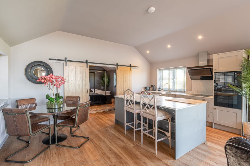 At Bearskin, the bedroom shows a freestanding bath under a window with blinds and a desk area beyond the bed.