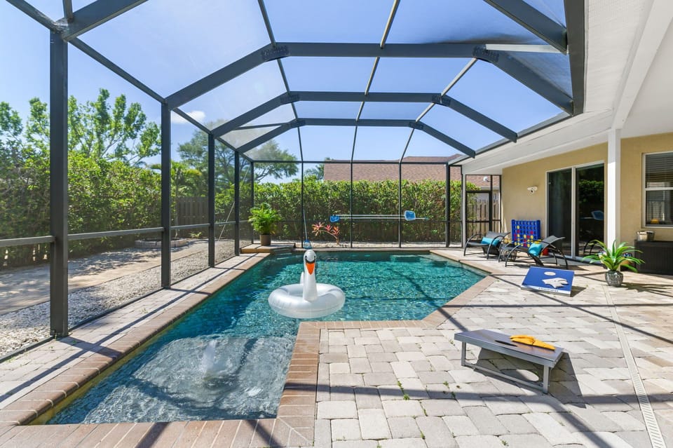 Outdoor screened-in patio with lots of comfortable seating, games and luxurious saltwater pool with Pebble Tec finish!
