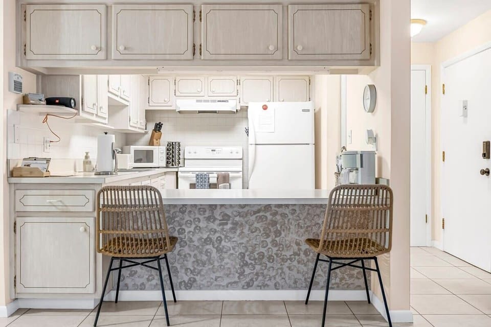 Cozy kitchen with a breakfast bar and wicker seating for casual dining.