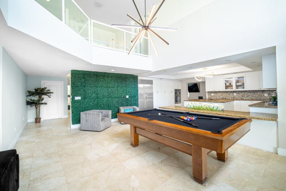 Stunning open-concept loft with a billiards table and dramatic lighting.