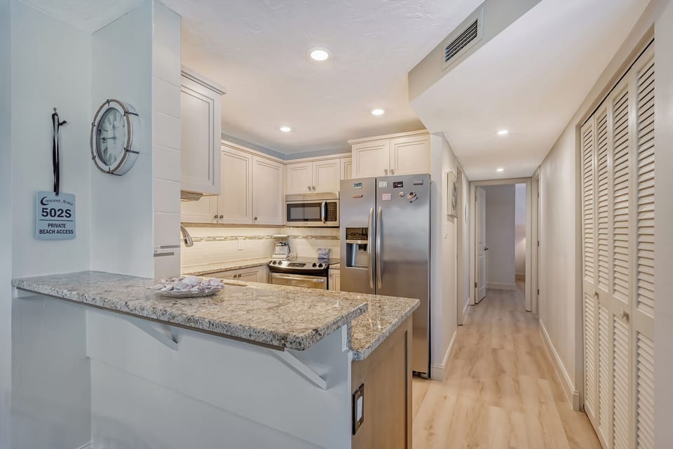 Modern, fully equipped kitchen with granite counters and all stainless appliances