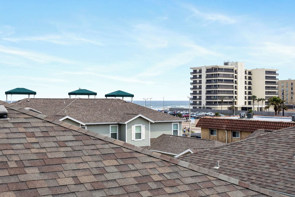 Rooftop view captures the coastal community with beach pavilions and oceanfront high-rises creating a charming seaside neighborhood atmosphere.