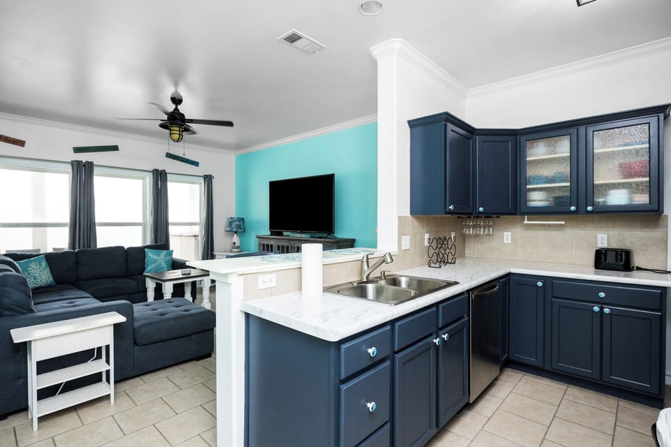 Your open-concept space blends kitchen and living seamlessly, with navy cabinets, granite counters, and cozy seating for memorable vacation moments.