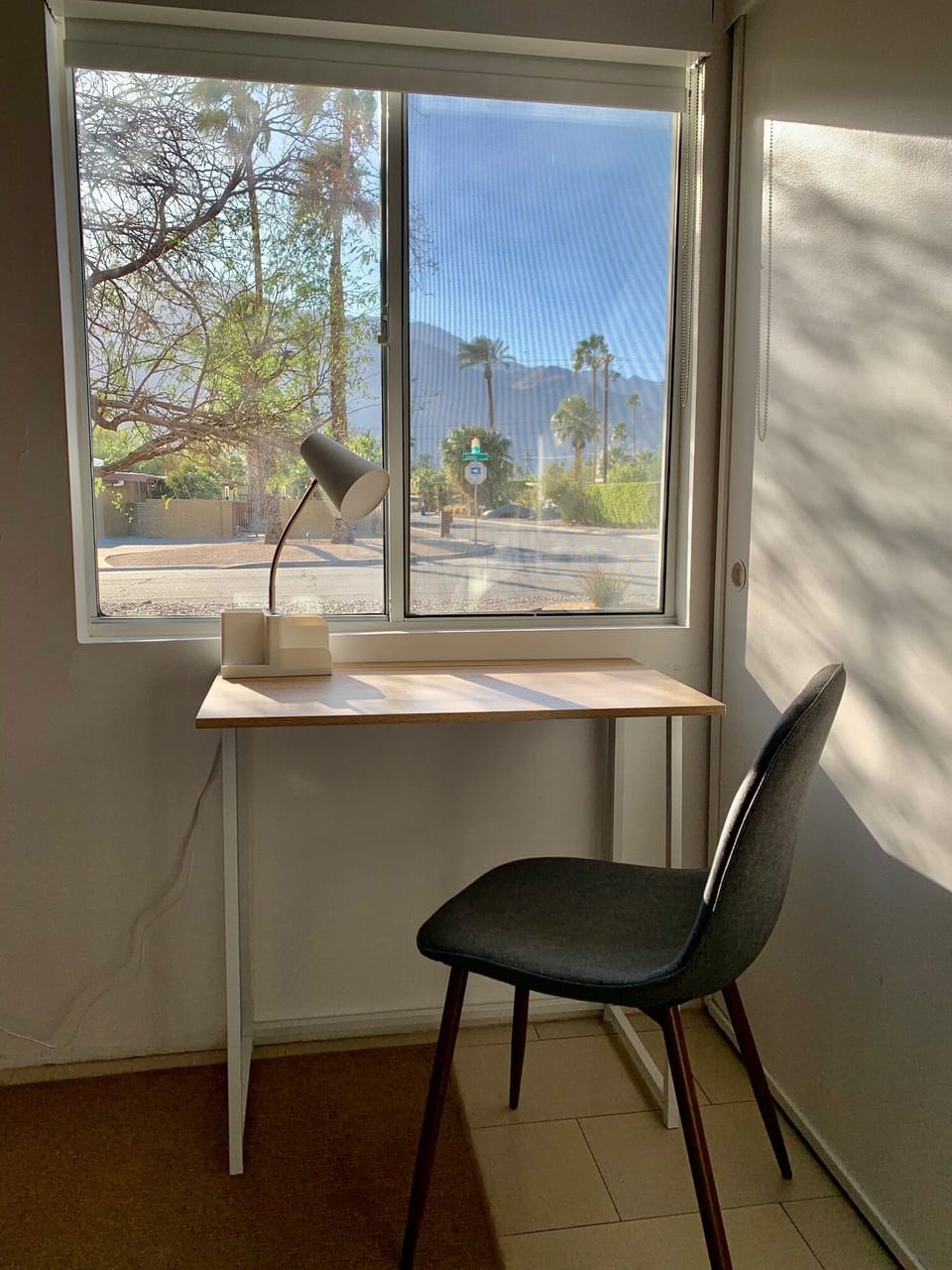 Queen room has a desk, light, outlets, chair and view of the mountains.