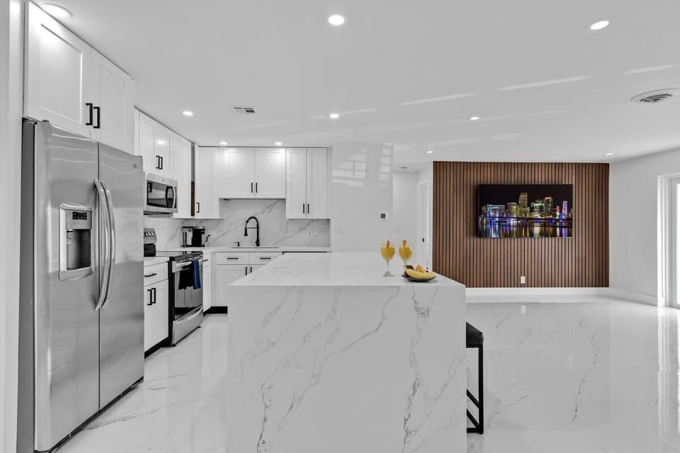 Modern kitchen with sleek cabinetry, stylish lighting & high-end appliances