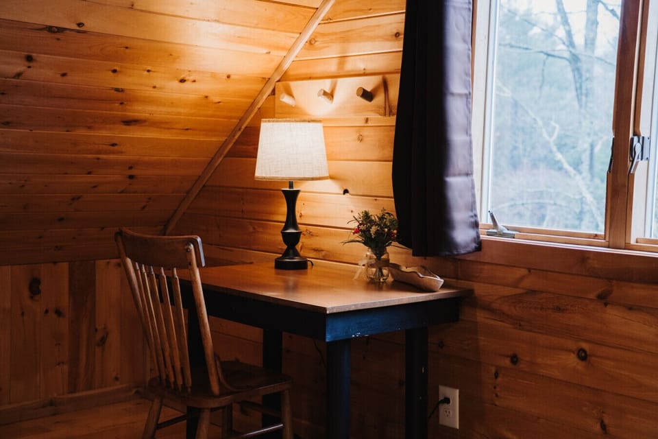 Located in the upstairs loft this practical desk is tucked in the corner of the room facing one of the windows for natural lighting. Perfect for writing with  task lighting. Note: this desk is located within the shared open sleeping area.