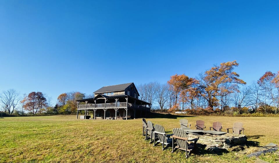Discover The Lodge, the perfect retreat for up to 14 guests, featuring breathtaking views and endless outdoor fun. Enjoy the wrap-around deck, volleyball court, fire pit, hot tub, and yard games for unforgettable memories!