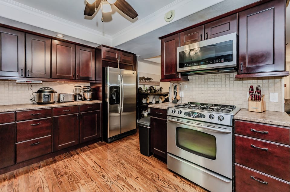 Fully equipped modern kitchen, perfect for cooking up gourmet vacation meals. With sleek dark wood cabinets, stainless steel appliances, and a beautiful nature backdrop, this kitchen is both functional and inviting.