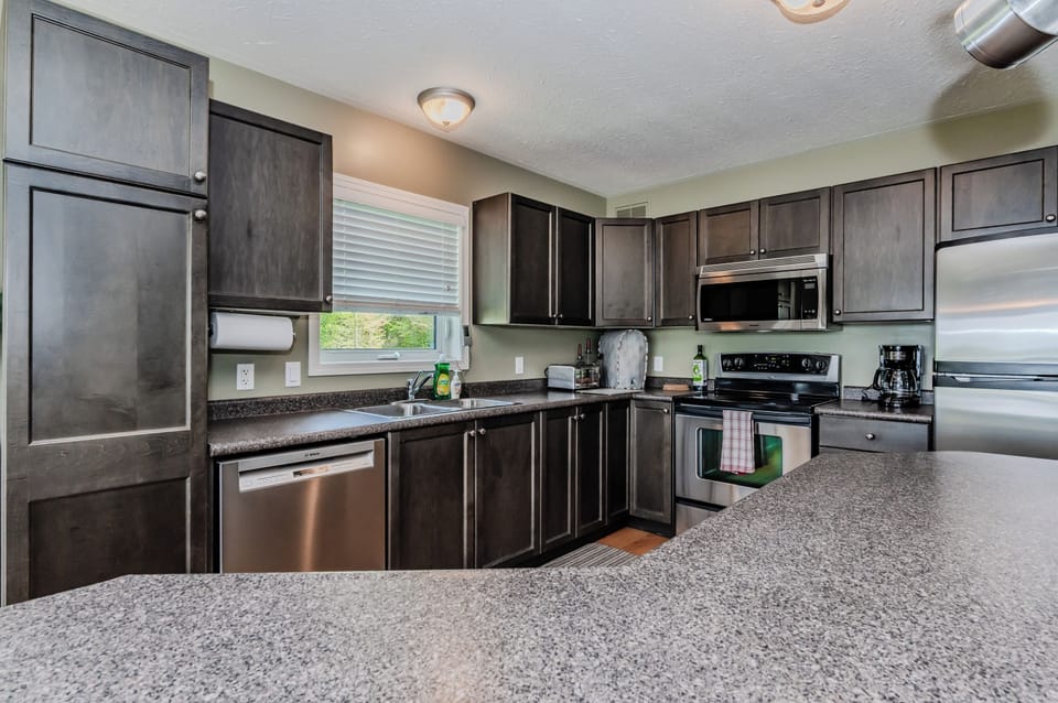 The inviting kitchen island is your hub for morning chatter and evening feasts, all with a side of stunning lake views.