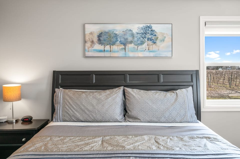 Main level bedroom w/ king bed, clean linens, bedside lighting, closet, dresser