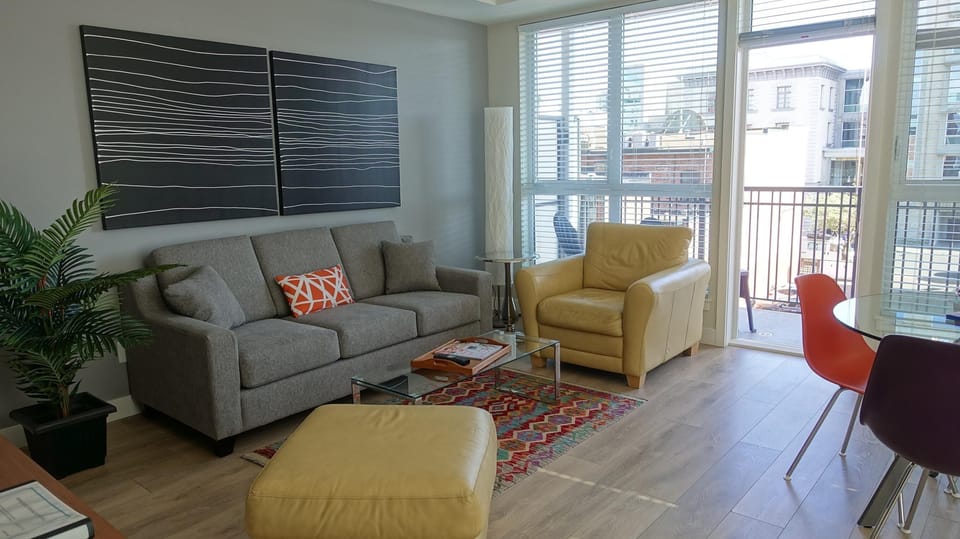Secondary living room view showing floor-to-ceiling exterior windows and adjacent dining space.