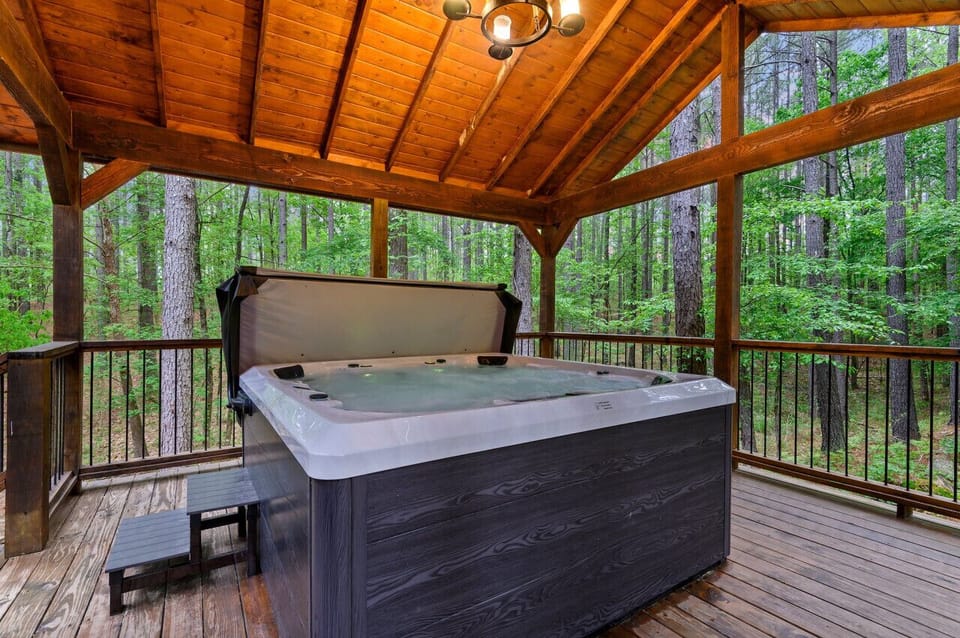 Covered deck with hot tub and forest views - spa amenity